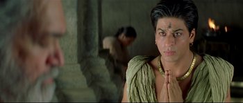 Movie still from “Asoka” (2001), directed by Santosh Sivan – A young man with his hands in a prayer position; Close Up shot, High angle
