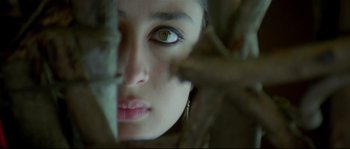 Movie still from “Asoka” (2001), directed by Santosh Sivan – A woman's face through leaves; Extreme Close Up shot, Low angle