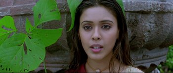 Movie still from “Asoka” (2001), directed by Santosh Sivan – A person wearing a red shirt near a tree; Close Up shot, Overhead angle