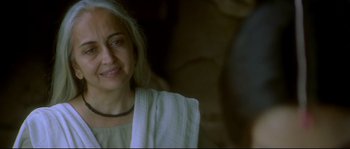 Movie still from “Asoka” (2001), directed by Santosh Sivan – An older woman is smiling for the camera; Close Up shot, Low angle