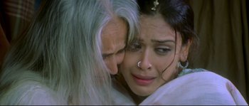 Movie still from “Asoka” (2001), directed by Santosh Sivan – An old man hugging a woman with a nose ring; Close Up shot, High angle