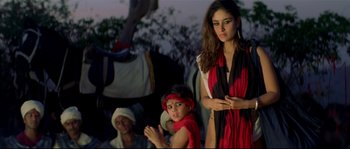 Movie still from “Asoka” (2001), directed by Santosh Sivan – A woman standing next to a young boy and another woman; Medium shot, Low angle