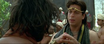 Movie still from “Asoka” (2001), directed by Santosh Sivan – A man with long black hair is looking at another man with long black hair; Close Up shot, Over the shoulder angle