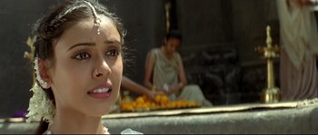 Movie still from “Asoka” (2001), directed by Santosh Sivan – A young girl sitting in front of a bunch of oranges; Close Up shot, High angle
