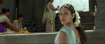 Movie still from “Asoka” (2001), directed by Santosh Sivan – A woman in a blue dress standing in front of a fountain; Close Up shot, Over the shoulder angle