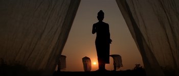 Movie still from “Asoka” (2001), directed by Santosh Sivan – A silhouette of a person standing in front of the setting sun; Extreme Wide shot, Low angle