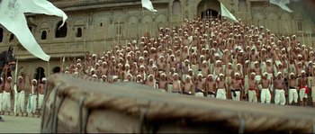 Movie still from “Asoka” (2001), directed by Santosh Sivan – A large group of men in white caps and white hats; Extreme Wide shot, High angle