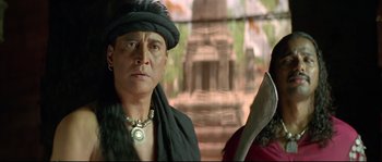 Movie still from “Asoka” (2001), directed by Santosh Sivan – A man wearing a black turban and a black hat; Close Up shot, Low angle