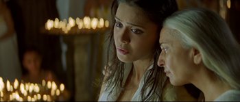 Movie still from “Asoka” (2001), directed by Santosh Sivan – Two women standing next to each other in front of lights; Close Up shot, Low angle