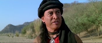 Movie still from “Asoka” (2001), directed by Santosh Sivan – A woman with a black hat and a necklace; Close Up shot, Low angle