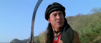 Movie still from “Asoka” (2001), directed by Santosh Sivan – A man with long black hair holding a sword in his hand; Close Up shot, Low angle