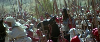 Movie still from “Asoka” (2001), directed by Santosh Sivan – A group of people on horses in a field; Wide shot, High angle