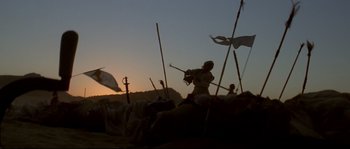 Movie still from “Asoka” (2001), directed by Santosh Sivan – A man holding a sword in a field; Wide shot, Low angle
