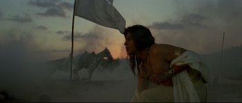 Movie still from “Asoka” (2001), directed by Santosh Sivan – A woman in a field with a horse behind it; Medium shot, Low angle