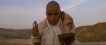 Movie still from “Asoka” (2001), directed by Santosh Sivan – A man holding a bowl in his hands; Medium shot, Low angle