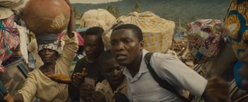 Movie still from “Beasts of No Nation” (2015), directed by Cary Joji Fukunaga – A group of men standing next to each other on a field; Close Up shot, Over the shoulder angle
