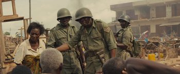Movie still from “Beasts of No Nation” (2015), directed by Cary Joji Fukunaga – A group of men dressed in military uniforms shaking hands; Medium shot, Over the shoulder angle