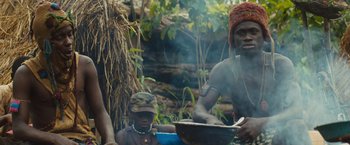 Movie still from “Beasts of No Nation” (2015), directed by Cary Joji Fukunaga – A group of people sitting around a fire pit; Medium shot, Low angle