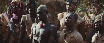 Movie still from “Beasts of No Nation” (2015), directed by Cary Joji Fukunaga – A group of men standing next to each other; Close Up shot, High angle