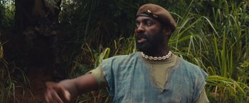 Movie still from “Beasts of No Nation” (2015), directed by Cary Joji Fukunaga – A man wearing a brown hat and a blue shirt; Close Up shot, Low angle