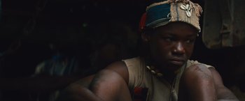 Movie still from “Beasts of No Nation” (2015), directed by Cary Joji Fukunaga – A person wearing a hat; Close Up shot, Low angle