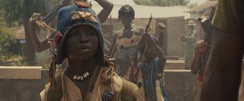 Movie still from “Beasts of No Nation” (2015), directed by Cary Joji Fukunaga – A group of people standing next to each other on a field; Close Up shot, Low angle