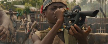 Movie still from “Beasts of No Nation” (2015), directed by Cary Joji Fukunaga – A young boy holding a bicycle wheel in his hands; Close Up shot, High angle