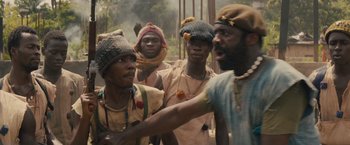 Movie still from “Beasts of No Nation” (2015), directed by Cary Joji Fukunaga – A group of men standing next to each other on top of a hill; Medium shot, Over the shoulder angle