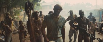 Movie still from “Beasts of No Nation” (2015), directed by Cary Joji Fukunaga – A group of people walking down a street; Medium shot, Low angle