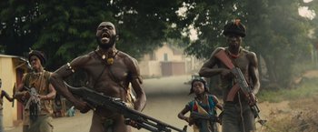 Movie still from “Beasts of No Nation” (2015), directed by Cary Joji Fukunaga – A group of people standing next to each other holding guns; Medium shot, Low angle