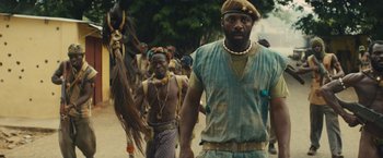 Movie still from “Beasts of No Nation” (2015), directed by Cary Joji Fukunaga – A group of people walking down a dirt road; Medium shot, Low angle