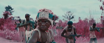 Movie still from “Beasts of No Nation” (2015), directed by Cary Joji Fukunaga – A group of young men standing next to each other; Medium shot, Low angle