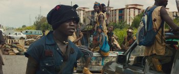 Movie still from “Beasts of No Nation” (2015), directed by Cary Joji Fukunaga – A group of people sitting on top of a truck; Close Up shot, High angle