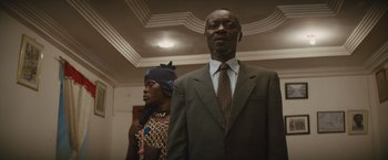 Movie still from “Beasts of No Nation” (2015), directed by Cary Joji Fukunaga – A man and a woman standing next to each other; Medium shot, Low angle