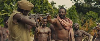 Movie still from “Beasts of No Nation” (2015), directed by Cary Joji Fukunaga – A group of men standing next to each other holding guns; Medium shot, Low angle
