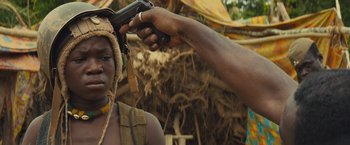 Movie still from “Beasts of No Nation” (2015), directed by Cary Joji Fukunaga – A man is holding a gun up to a woman's face; Close Up shot, Over the shoulder angle