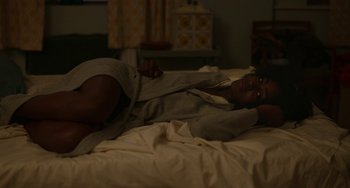 Movie still from “Behind Her Eyes” (2021), directed by Erik Richter Strand – A person laying on a bed in a room; Medium shot, High angle