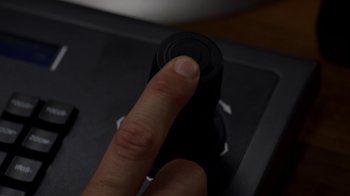 A hand is pressing a button on a computer keyboard
