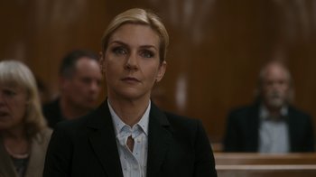 Movie still from “Better Call Saul” (2015), created by Vince Gilligan – A woman wearing a suit and tie sitting in a courtroom; Close Up shot, Over the shoulder angle