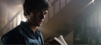 Movie still from “Black Mirror: Bandersnatch” (2018), directed by David Slade – A young man is holding papers in his hands; Close Up shot, Low angle