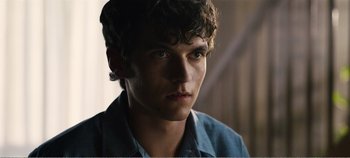 Movie still from “Black Mirror: Bandersnatch” (2018), directed by David Slade – A young man is looking into the distance; Close Up shot, Over the shoulder angle
