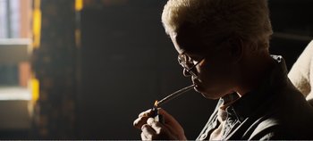 Movie still from “Black Mirror: Bandersnatch” (2018), directed by David Slade – A man with a cigarette in his mouth; Medium shot, Low angle