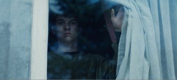 Movie still from “Black Mirror: Bandersnatch” (2018), directed by David Slade – A man looking out of a window at night; Medium shot, Low angle