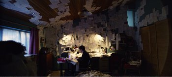 Movie still from “Black Mirror: Bandersnatch” (2018), directed by David Slade – A man sitting at a desk in front of a computer; Wide shot, High angle