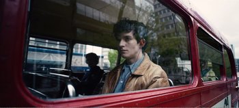 Movie still from “Black Mirror: Bandersnatch” (2018), directed by David Slade – A man sitting in the driver's seat of a red car; Close Up shot, High angle