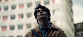 Movie still from “Black Mirror: Bandersnatch” (2018), directed by David Slade – A man with curly hair looking up at the sky; Close Up shot, Low angle