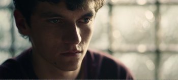 Movie still from “Black Mirror: Bandersnatch” (2018), directed by David Slade – A young man's face; Close Up shot, Over the shoulder angle