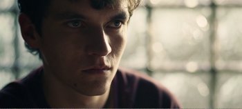 Movie still from “Black Mirror: Bandersnatch” (2018), directed by David Slade – A young man's face; Close Up shot, Over the shoulder angle