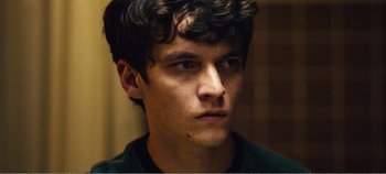 Movie still from “Black Mirror: Bandersnatch” (2018), directed by David Slade – A young man is looking into the distance; Close Up shot, Low angle