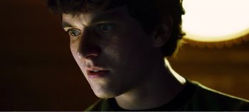 Movie still from “Black Mirror: Bandersnatch” (2018), directed by David Slade – A young man's face in the dark; Close Up shot, Low angle